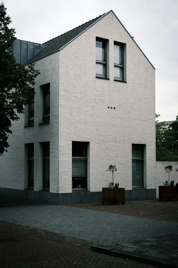 Real photograph of a modern white brick building with dark windows