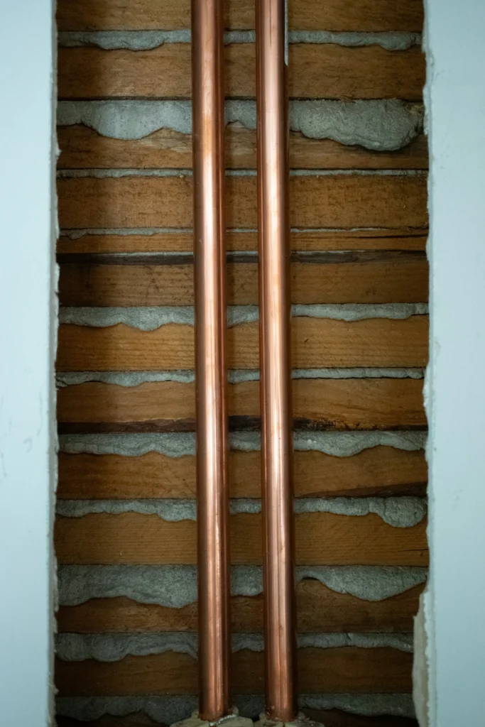 Real photograph of exposed copper pipework during renovation