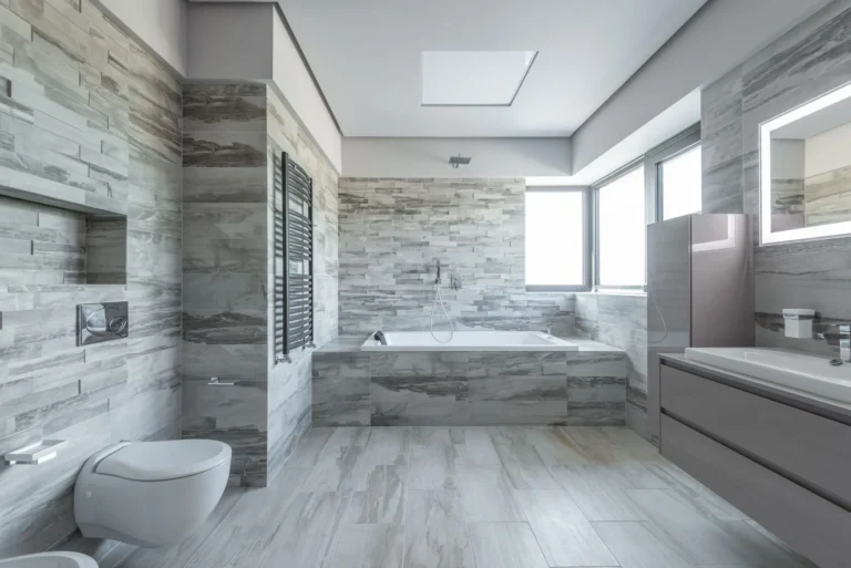 Pale stone wall and floor tiles around a fitted bath
