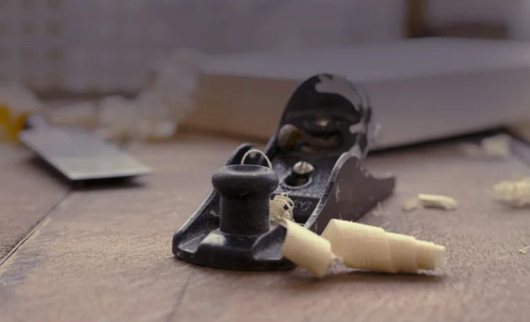 Real photograph of a hand plane, timber shavings and tools on a joinery workbench